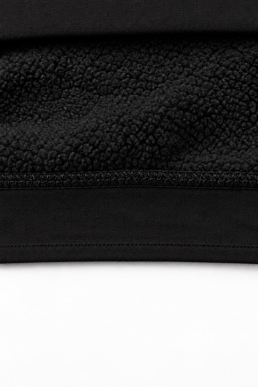 THE TRACE black — interior fleece fabric detail, smooth plain hem, no ribbing